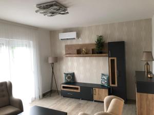 a living room with a couch and a tv at Viola Apartmans Lux in Šušanj