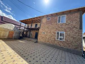 a brick building with a cover on the side of it at Center guesthouse in Kochkorka