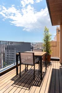 a wooden deck with a bench and a table on a balcony at Europark in Barcelona