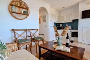 a living room with a table with a bottle of wine at Mar & Calma in Son Bou