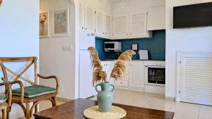 a kitchen with a table and a vase on a table at Mar & Calma in Son Bou +17 photos