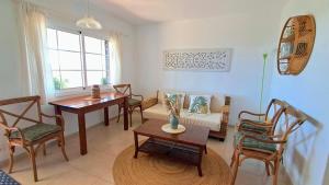 a living room with a couch and a table and chairs at Mar & Calma in Son Bou
