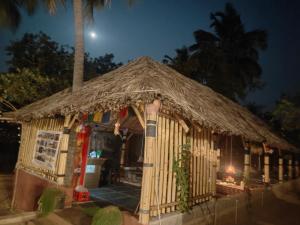 a small hut with a straw roof at night at Crazzy Panda Hampi in Hampi