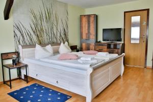 a bedroom with a large white bed with pink pillows at Bordmann` Scheune in Kolonie