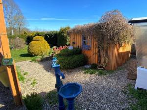 a small garden with a small house and a statue at Ferienhaus Deubel Escobar in Kappeln +9 photos