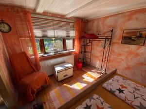 a small room with a bed and a chair and a window at Ferienhaus Deubel Escobar in Kappeln