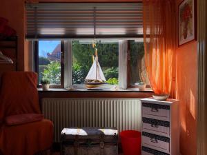 a window with a small sail boat in a room at Ferienhaus Deubel Escobar in Kappeln