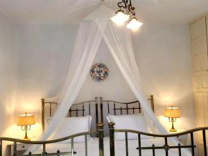a bedroom with a bed with a canopy and two lamps at Pepromeno Boutique in Agios Dimitrios
