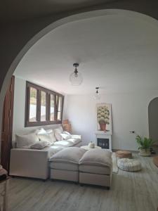 a living room with a white couch and a window at Amira home suite in Sant Pere de Ribes