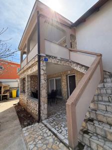 a house with a staircase in front of it at SeaLaVir Apartments in Vir