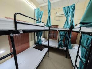 a room with three bunk beds in a dorm room at Evara Stays Backpackers Hostel in Kolkata