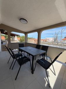 a dining room with a table and chairs on a balcony at SeaLaVir Apartments in Vir