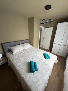 a bed with two blue pillows on top of it at SeaLaVir Apartments in Vir