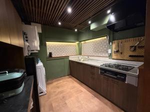 a green kitchen with a sink and a stove at 一棟貸し宿 maicca2 in Numazu +58 photos