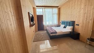 a small bedroom with a bed and a window at Harsil River Retreat in Harsil