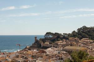 a town on a hill with the ocean in the background at Feelathome Vil-la Romana in Tossa de Mar