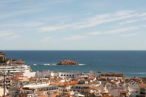 a city with buildings and a rock in the ocean at Feelathome Vil-la Romana in Tossa de Mar
