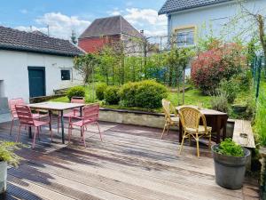 a wooden deck with chairs and a table and a table and chairs at La chambre 1911 in Ars-sur-Moselle