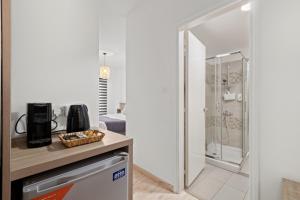 a kitchen with a walk in shower next to a counter at Larnaca Bay Suites in Larnaca +47 photos