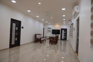 a hallway with chairs and a television in a building at Premium House or Office In Amaravati in Sūriapālem
