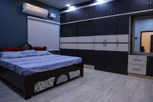 a bedroom with a bed and a mirror and cabinets at Premium House or Office In Amaravati in Sūriapālem