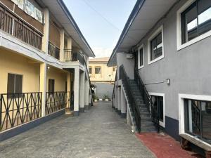 an alley between two buildings with a stairway between them at Caligeo Suites I in Ibadan