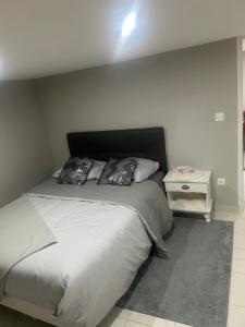 a bedroom with a large bed with a night stand at Chez Lina in Chartres
