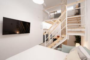 a living room with a staircase and a tv at Baélia Experience Hotel boutique in Alicante