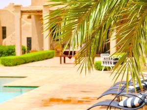a palm tree in front of a building with a pool at Palais Nova in Marrakesh