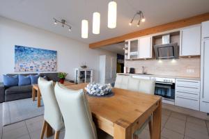 a kitchen and living room with a wooden table and chairs at Nr 17 Penthouse Meerblick in Schönhagen