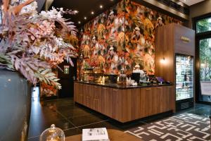 a bar in a restaurant with a floral wall at Hotel AMANO Grand Central in Berlin