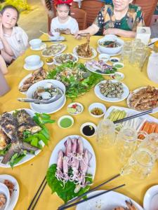 a long table with plates of food on it at Bạch Tuyết Hotel in Cửa Lô