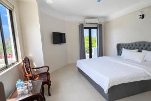 a bedroom with a bed and a tv on the wall at Bạch Tuyết Hotel in Cửa Lô