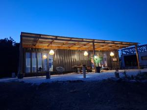 a wooden building with a table in front of it at night at Eco Hideaway in Anoyira