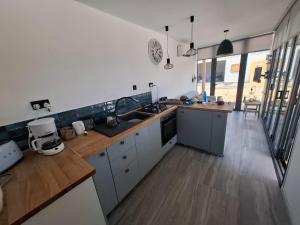 a kitchen with white cabinets and a wooden floor at Eco Hideaway in Anoyira