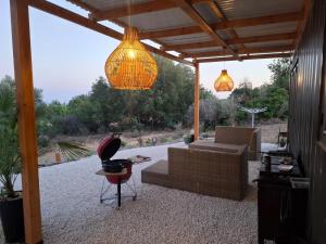 a patio with a couch and a chair and lights at Eco Hideaway in Anoyira +3 photos