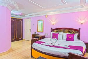 a bedroom with pink walls and a bed with pink pillows at Hotel Mount View in Kodaikānāl +61 photos