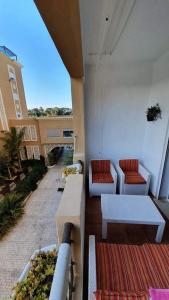 a balcony with couches and tables on a building at Studio with private beach Folla Residence in Akouda