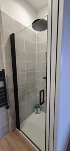 a shower with a glass door in a bathroom at Appartement coquet proche plage in Berck-sur-Mer