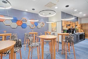 a restaurant with tables and chairs and a counter at Scandic Ruoholahti in Helsinki +7 photos