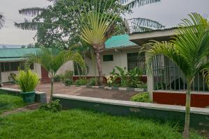 a house with palm trees in front of it at Kiusa Badget Hotel in Moshi +27 photos