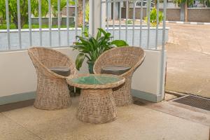 two wicker chairs and a table on a porch at Kiusa Badget Hotel in Moshi