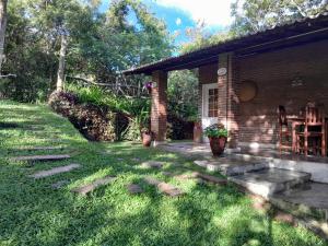 a brick house with a pathway leading to a yard at Chalé Guaíras in Mulungu +26 photos