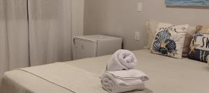 a bedroom with a bed with a towel on it at Chalés da Cris in Fortim