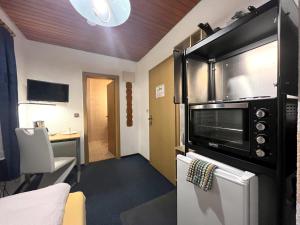 a room with a microwave and a kitchen with a table at BLACKCOMs Erika in Goslar
