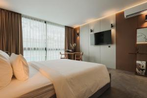 a hotel room with a bed and a flat screen tv at Awwa Boutique Hotel in Canggu