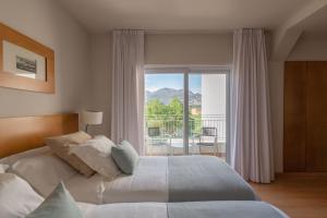 a bedroom with a bed and a view of a balcony at Hotel & Spa Terraza 4 Sup in Roses +47 photos