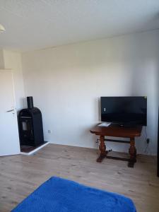 ein Wohnzimmer mit einem Tisch und einem Ofen in der Unterkunft Charmant 90 E in Lichterfelde