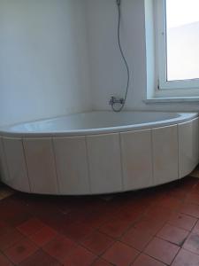 eine weiße Badewanne in einem Zimmer mit Fenster in der Unterkunft Charmant 90 E in Lichterfelde + 7 Fotos