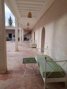 a room with a bed and tables and chairs at Riad NACIRIA in Aït Ourir